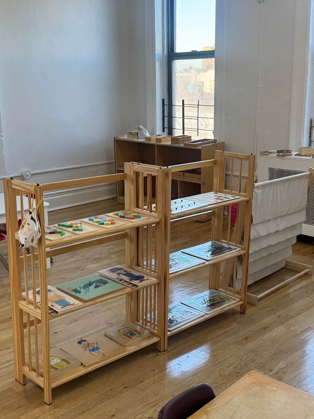 Low shelves of puzzles and Montessori materials at child height